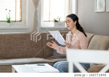 Purchase of real estate. Young caucasian woman watching documents in office. Concept of leasing, business and mortgage Purchase of real estate. Young caucasian woman watching documents in office. Concept of leasing, business and mortgage 100771846