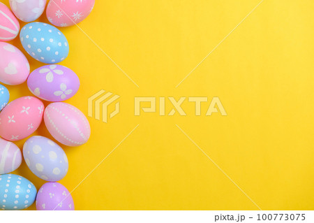 Happy easter holiday celebration concept. Group of painted colourful eggs decoration on a yellow background. Seasonal religion tradition design. Top view, flat lay, copy space. 100773075