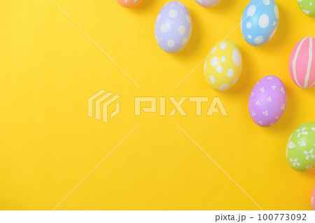 Happy easter holiday celebration concept. Group of painted colourful eggs decoration on a yellow background. Seasonal religion tradition design. Top view, flat lay, copy space. Happy easter holiday celebration concept. Group of painted colourful eggs decoration on a yellow background. Seasonal religion tradition design. Top view, flat lay, copy space. 100773092