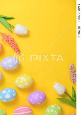 Happy Easter holiday greeting card design concept. Colorful Easter Eggs and spring flowers on yellow background. Flat lay, top view, copy space. Happy Easter holiday greeting card design concept. Colorful Easter Eggs and spring flowers on yellow background. Flat lay, top view, copy space. 100773093