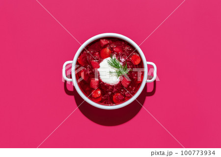 Beetroot soup bowl minimalist on pink table. Borscht with sourcream. 100773934