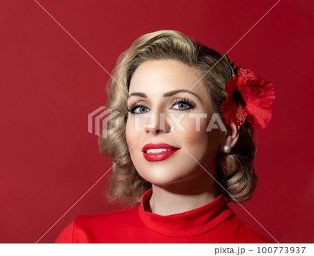 Retro hairstyle woman against a red background. Pin-up woman portrait 100773937