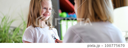 Pediatrician listens to lungs of little girl child with stethoscope 100775670