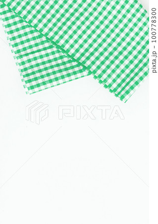 Green cloth, a kitchen towel with a checkered pattern, on a white background isolated 100778300