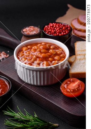 Delicious canned beans in a tomato in a white ceramic bowl 100778973