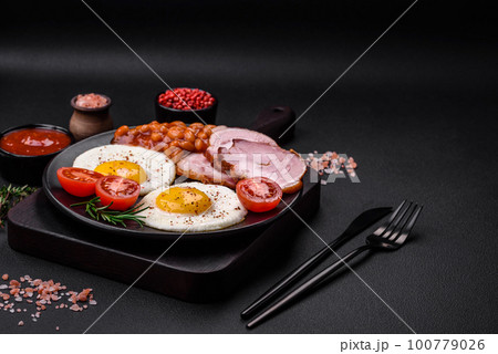 Delicious nutritious English breakfast with fried eggs and tomatoes 100779026