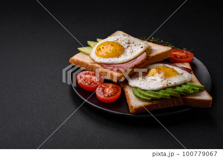 Delicious nutritious English breakfast with fried eggs, tomatoes and avocado Delicious nutritious English breakfast with fried eggs, tomatoes and avocado 100779067