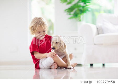 Child playing with dog. Kids play with puppy. Child playing with dog. Kids play with puppy. 100779450