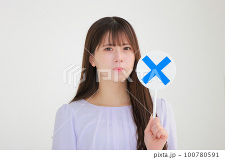 バツのプレートを持つ若い女性1 100780591