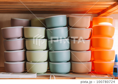 Multicolored silicone baby tableware stack, different forms of tureen on shelf of the store. Kid healthcare, First feed 100780724