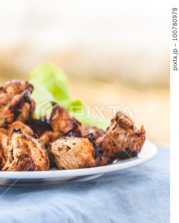 Pieces of meat-shish kebab on a white plate with a green salad Pieces of meat-shish kebab on a white plate with a green salad 100780978