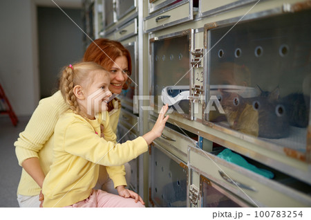 Happy mother with little daughter visiting animal shelter Happy mother with little daughter visiting animal shelter 100783254