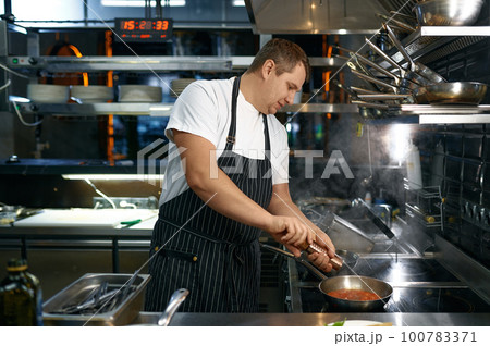 Chef adding pepper to sauce with tomato for pasta 100783371