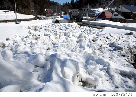 早春の残り雪を早く取り除くために細かく崩しておく　福島県只見町 100785479