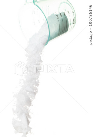 Refined Salt fall down pouring in measured cup, powder white salts explode abstract cloud fly. Small ground salt splash in air, food object element design. White background isolated high speed freeze Refined Salt fall down pouring in measured cup, powder white salts explode abstract cloud fly. Small ground salt splash in air, food object element design. White background isolated high speed freeze 100786146