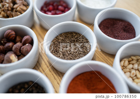 set of spices on wooden background, caraway cumin, hazelnut, pine nut set of spices on wooden background, caraway cumin, hazelnut, pine nut 100786350