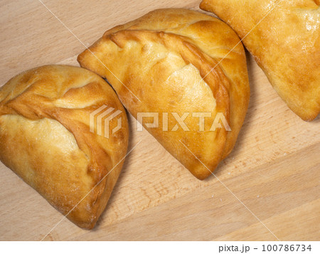 National bakery. A pie with cabbage. Pies with stuffing on the table. Cuisine of the countries of the world. 100786734