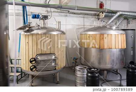 Large beer tanks in brew house 100789389