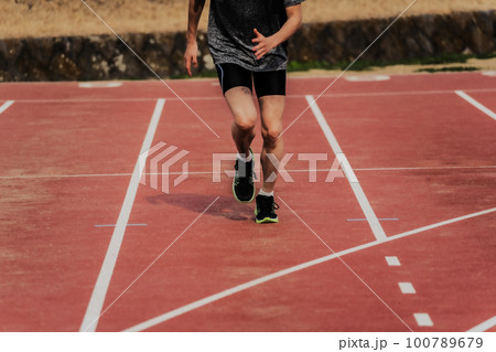 陸上競技場のトラックでスタートダッシュする男性ランナー 陸上競技場のトラックでスタートダッシュする男性ランナー 100789679