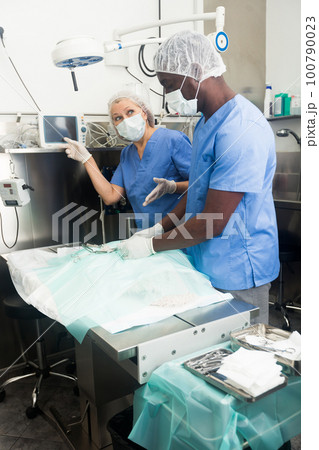 Nurse points to surgeon on computer screen 100790023