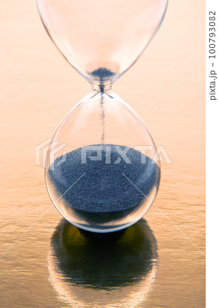 hourglass on a golden background. time and minute measurement 100793082