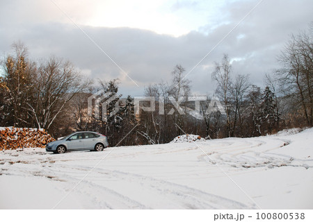 Ice blue car driving on a trail through a snowy white forest in Harz mountains, Germany 100800538