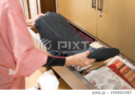 着物ダンスに着物を片付けるシニア女性 着物ダンスに着物を片付けるシニア女性 100802085
