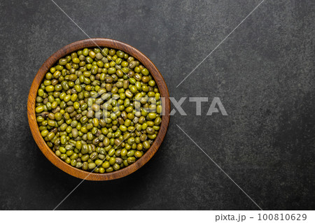 Top view of raw green mung beans in wooden bowl Top view of raw green mung beans in wooden bowl 100810629