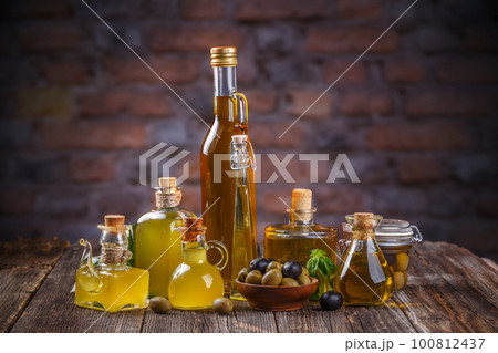 Various olive oil glass bottles with olive berries 100812437