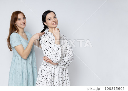 Two beautiful young women, sisters - twins on white background 100815603