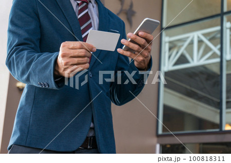 Businessman showing blank business card and holding smart phone..Business man holding white blank card space for text. product display montage. Businessman showing blank business card and holding smart phone..Business man holding white blank card space for text. product display montage. 100818311