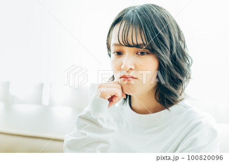 部屋で考え事をする若い女性 部屋で考え事をする若い女性 100820096