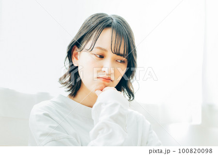 部屋で考え事をする若い女性 部屋で考え事をする若い女性 100820098