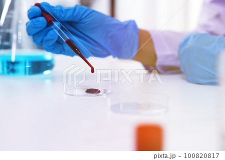 Scientist holding Coronavirus covid-19 infected blood sample tube DNA testing of the blood in the laboratory with blood sample collection tubes and syringe Coronavirus Covid-19 vaccine research. Scientist holding Coronavirus covid-19 infected blood sample tube DNA testing of the blood in the laboratory with blood sample collection tubes and syringe Coronavirus Covid-19 vaccine research. 100820817