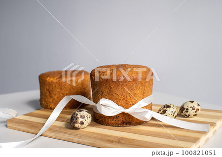 Easter pastries , sponge cake on a wooden board . Quail eggs. Place for text Easter pastries , sponge cake on a wooden board . Quail eggs. Place for text 100821051