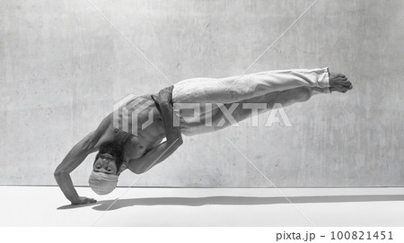 Black and white image, monochrome. Strong body. Muscular shirtless man practising yoga exercises against textured background Black and white image, monochrome. Strong body. Muscular shirtless man practising yoga exercises against textured background 100821451
