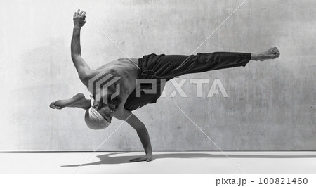 Black and white image, monochrome. Standing at one hand. Bearded strong man training shirtless, practising yoga exercises Black and white image, monochrome. Standing at one hand. Bearded strong man training shirtless, practising yoga exercises 100821460
