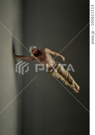 Bearded shirtless man practising yoga, training over dark studio background. Muscular, healthy, fit body shape Bearded shirtless man practising yoga, training over dark studio background. Muscular, healthy, fit body shape 100821514