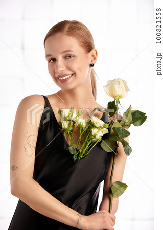 Beautiful young with special needs woman with flowers in her hand holding a flower, woman in black dress. Diversity women with disability and flowers. Beautiful young with special needs woman with flowers in her hand holding a flower, woman in black dress. Diversity women with disability and flowers. 100821558