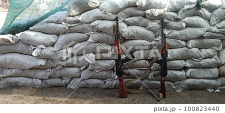 Two Kalashnikovs standing near sandbagged fortifications. AK-74 outdoor 100823440