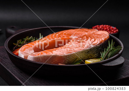 Fresh raw red fish steak with spices and herbs 100824383