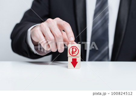 Wooden blocks with red currency ruble icon and red arrow down. Growth and depreciation concept. 100824512