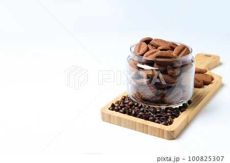 Concept of tasty snack for hot drink - cookies in the shape of coffee seeds Concept of tasty snack for hot drink - cookies in the shape of coffee seeds 100825307