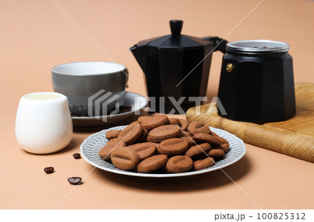 Concept of tasty snack for hot drink - cookies in the shape of coffee seeds 100825312