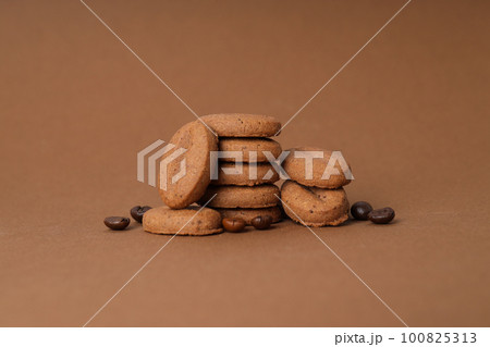 Concept of tasty snack for hot drink - cookies in the shape of coffee seeds Concept of tasty snack for hot drink - cookies in the shape of coffee seeds 100825313