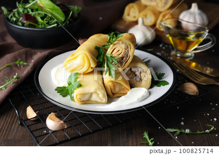 Concept of tasty food, thin pancakes with filling Concept of tasty food, thin pancakes with filling 100825714