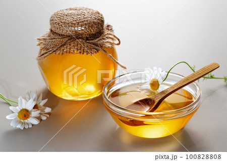 Chamomile syrup in a small bowl and jar on the kitchen table Chamomile syrup in a small bowl and jar on the kitchen table 100828808