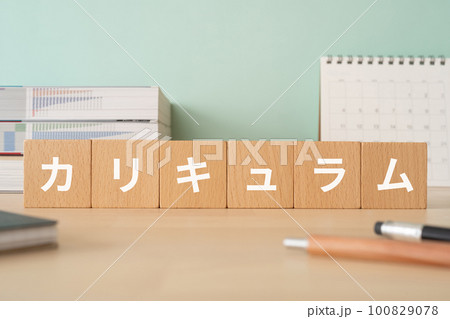 カリキュラムと書かれたブロックが置かれたデスク 100829078