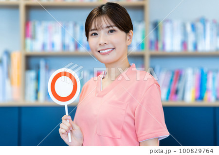 OKのプレートを出す介護スタッフの若い女性 100829764