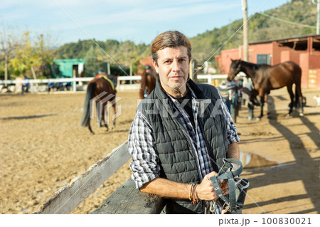 Owner of the stable poses in front of corral for horses 100830021